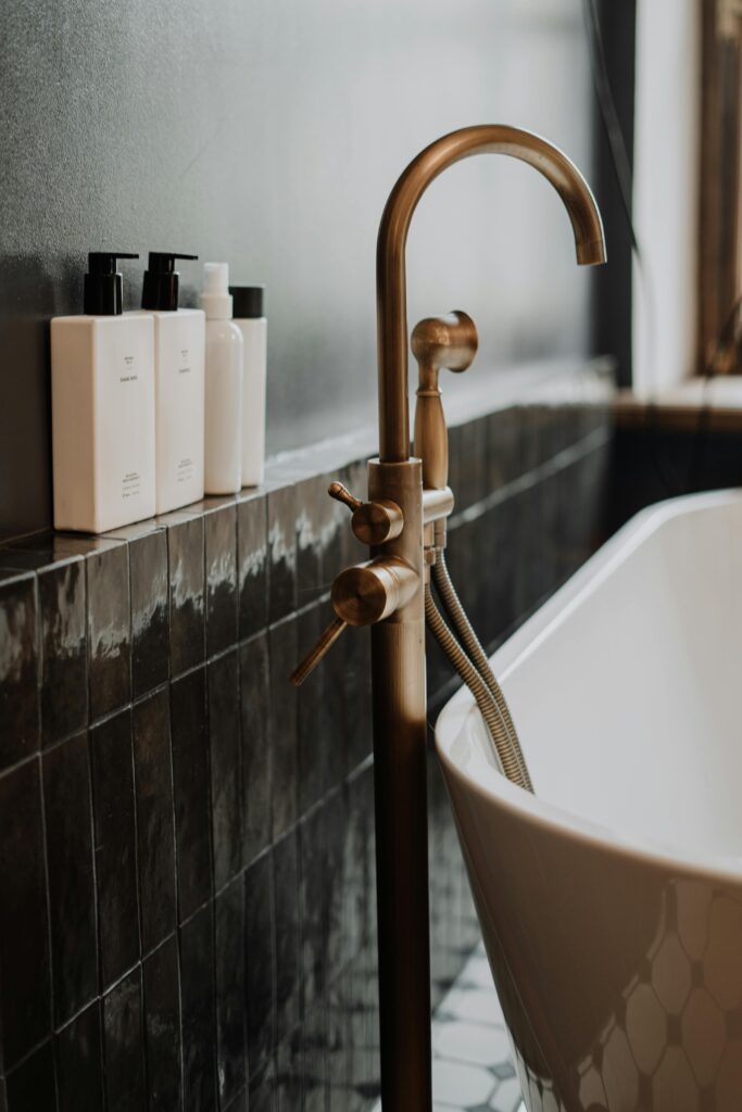 pexels-photo-4153152-4153152 A modern bathroom with gold fixtures and minimalist soap bottles enhancing its elegant appeal.